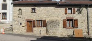 a stone building with brown doors and windows at Maison cosy en pierre parking centre in Vittel