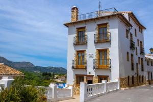 a white house with balconies on a street at La Casa del Carrebaix in Orba