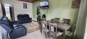 a dining room with a table and chairs and a television at Arenal Jendrik house in Agua Azul +21 photos