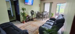 a living room with a couch and a dining room at Arenal Jendrik house in Agua Azul