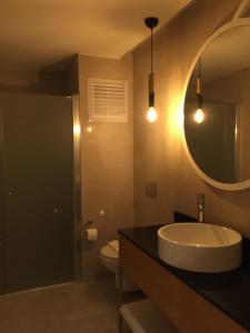 a bathroom with a sink and a mirror and a toilet at Çalcalar Otel in Ula