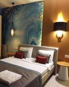 a bedroom with a large bed with a painting on the wall at Çalcalar Otel in Ula