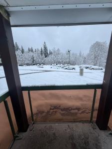 una vista di un campo innevato da una finestra di Charmant Studio a Prémanon