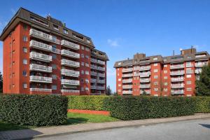 two tall apartment buildings with bushes next to a street at Assago Forum Apartment - MilanoFiori in Assago