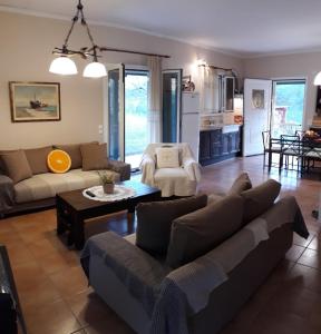 a living room with a couch and a table at Villa Freedom - Koutsoubri Beach Evia in Agriovótanon