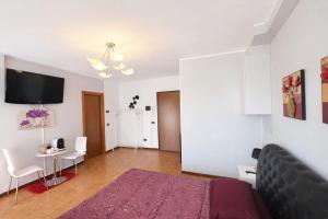 a bedroom with a bed and a table and a tv at Assago Forum Apartment - MilanoFiori in Assago