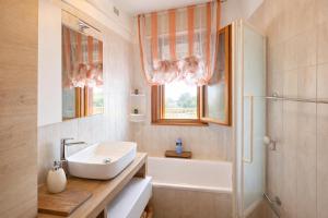 a bathroom with a sink and a tub and a shower at Assago Forum Apartment - MilanoFiori in Assago