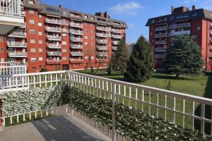 a balcony with a white fence and some buildings at Assago Forum Apartment - MilanoFiori in Assago