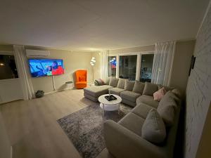 a living room with a couch and a tv at Langhaugen - Kabelvåg in Kabelvåg
