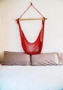 a red hammock hanging on a wall above a bed at C 33 Hospedaje Valladolid in Valladolid