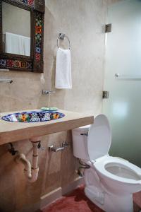 a bathroom with a toilet and a sink and a mirror at C 33 Hospedaje Valladolid in Valladolid +18 photos