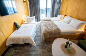 a hotel room with two beds and a window at New Gudauri Atrium 218 in Gudauri +18 photos