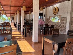 a restaurant with tables and chairs and a clock on the wall at Amarena Resorts in Bocapán