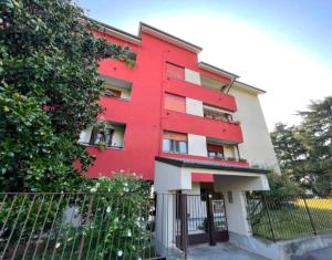 a red building with a fence in front of it at La Mini Home - Dove sentirsi subito a casa in Monza