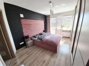 ein Schlafzimmer mit einem großen Bett und einer Holzwand in der Unterkunft Malina in Sulęcin
