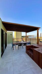 a patio with tables and chairs on a balcony at Brisa Rooftop Vistamar -Apartamento à beira mar com jacuzzi in Luis Correia