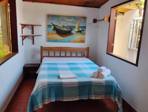 a bedroom with a bed with a blue and white blanket at Pousada Barracuda Pipa in Pipa