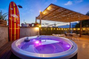 a hot tub on a patio with a surfboard at Villa Esterito - La Paz Baja California Sur in La Paz