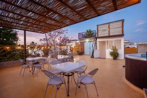 a patio with tables and chairs on a balcony at Villa Esterito - La Paz Baja California Sur in La Paz