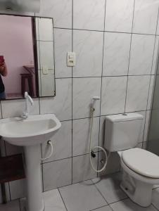 a bathroom with a sink and a toilet and a mirror at Pousada Barracuda Pipa in Pipa
