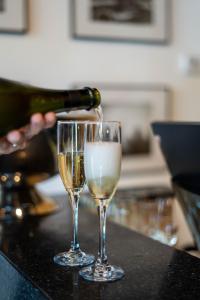 a person pouring champagne into two glasses on a counter at Upsun Hotel in Miami Beach