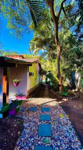 a walkway in front of a house with a tree at Casa Praiana Búzios in Búzios