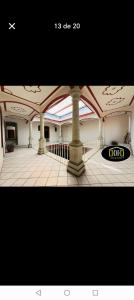 a large room with columns and a clock on the floor at Hotel san ignacio in Oaxaca City
