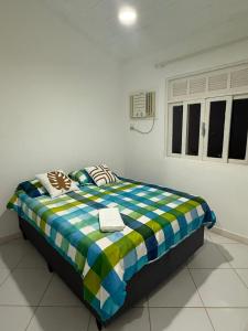 a bedroom with a bed with a book on it at Casa Praiana Búzios in Búzios