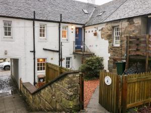 a house with a wooden fence in front of it at 1 The Cross in Dunkeld