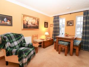 a living room with a chair and a table at 1 The Cross in Dunkeld