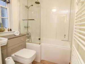 a white bathroom with a shower and a toilet at 1 The Cross in Dunkeld +21 photos