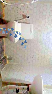 a bathroom with a white tiled wall with blue stars at Devagram Guest house in Dergaon