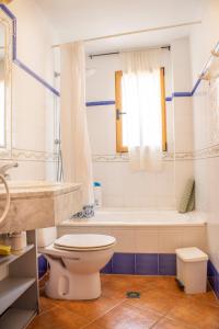 a bathroom with a toilet and a tub and a sink at La Casa del Carrebaix in Orba +250 photos
