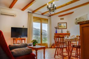 a living room with a television and a table with chairs at La Casa del Carrebaix in Orba