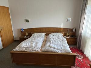 a bedroom with a bed with two pillows on it at Pension Katharina im Solling in Holzminden +18 photos