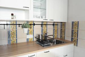 a kitchen with white cabinets and a sink at Żeromskiego 1 in Warsaw