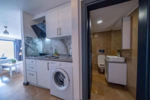 a kitchen with a washing machine and a sink at İlya Apart 2 in Bodrum City +41 photos