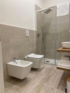a bathroom with a toilet and a sink and a shower at   +2 photos