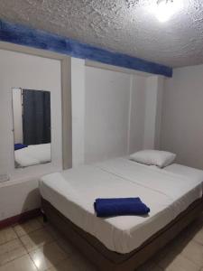 a bedroom with a bed with a blue towel on it at Casa Volcán Granada in Granada