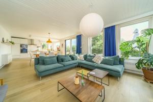 a living room with a blue couch and a table at Stormhus - Oostduinkerke in Koksijde