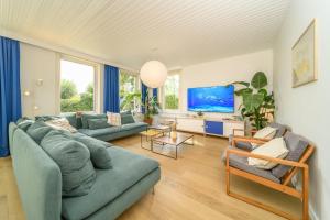 a living room with a couch and a tv at Stormhus - Oostduinkerke in Koksijde