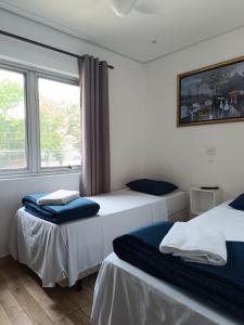 two beds in a room with a window at Hotel Connect Ibira Servidor Park in São Paulo