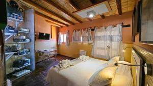 a bedroom with a bed and a table in a room at La Posada del Rio in Tilcara