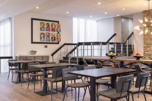 a restaurant with tables and chairs and a staircase at The Midtown Hotel MOD Collection by Sonesta in Boston