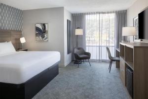 a hotel room with a bed and a chair at The Midtown Hotel MOD Collection by Sonesta in Boston