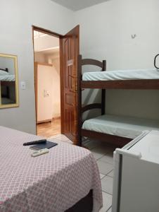 a room with a bed and a mirror and bunk beds at Pousada Riocabana in Barreirinhas