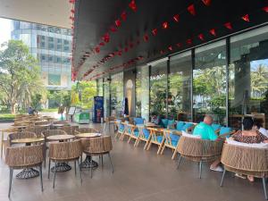 a group of people sitting at tables in a restaurant at AHoa StarCity with Seaview in Nha Trang