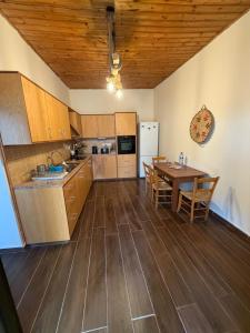 eine Küche mit Holzboden und Tisch in der Unterkunft Giorgoula house in Koilani