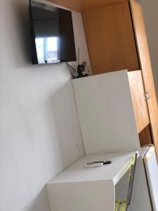 a room with a tv on top of a white refrigerator at Pousada Mayer in Paulo Afonso