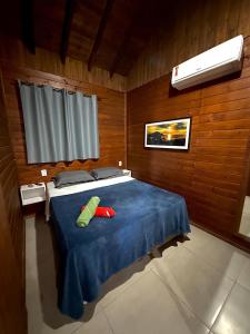 a bedroom with a blue bed with two pillows on it at POUSADA ROSA e POESIA in Praia do Rosa +37 photos